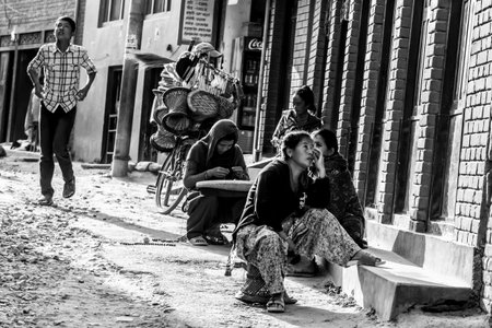 Kathmandu, Nepal - November 5, 2015: Nepalese people sitting along a street in central Kathmandu.
