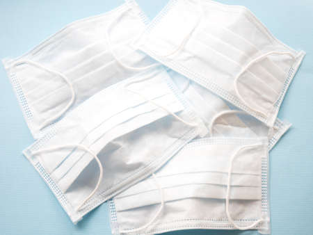 White medical masks on the blue background. Top view.の写真素材