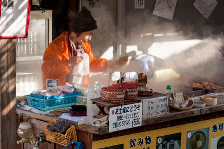 Beppu, Japan - December 29, 2009: Woman vendor cooking boiled eggs, popular street food in Beppu.のeditorial素材
