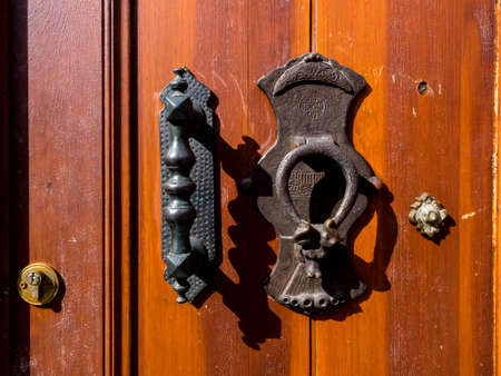 Fragment of the old wooden door with brass handles.の写真素材