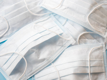 Background of white medical masks, top view. Medicine concept