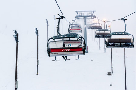 Ruka, Finland - November 24, 2012: Skiers are sitting on the chair ski lift at Ruka ski resort in...