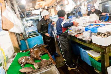 Tokyo, Japan - January 15, 2010: Vendor cutting fish at Tsukiji Fish Market. Early morning at the fish market.のeditorial素材