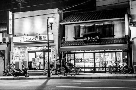 Kyoto, Japan - December 26, 2009: A man on a bicycle near the store on Gion street at nightのeditorial素材