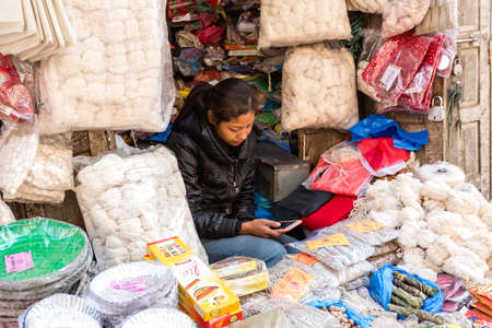 Kathmandu, Nepal - November 17, 2018: Woman sells spices and nuts at the street market in Kathmanduのeditorial素材