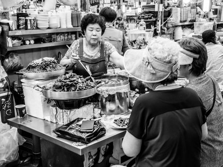 Seoul, South Korea - June 21, 2017: People eating tasty food and drink at Gwangjang Market in Seoul.のeditorial素材