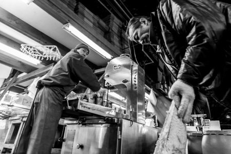 Tokyo, Japan - January 15, 2010: Early morning at Fish Market. Vendor cutting tuna at Tsukiji Fish Market.のeditorial素材