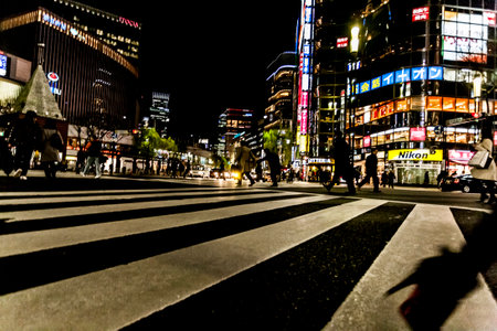 Tokyo, Japan - January 14, 2010: Pedestrians crossing the street at the heart of Ginza District in Tokyo. Ginza crossing at night. Blurred motion.のeditorial素材