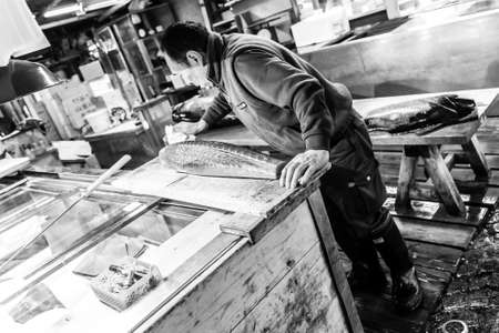 Tokyo, Japan - January 15, 2010: Adult worker cutting tuna in Tsukiji Fish Market at early morning.のeditorial素材