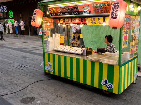 Suwon, South Korea - June 15, 2017: Seller woman waiting for buyers in her fast food kiosk at main street in Suwon.のeditorial素材