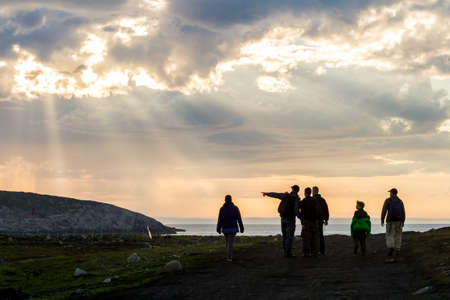 Teriberka, Russia - July 30, 2017: Group of tourists walking on the shore of the Arctic Ocean at sunset.のeditorial素材