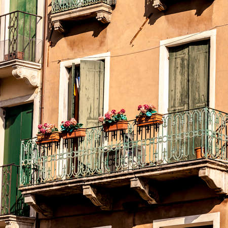 Old fashioned traditional balcony with flowers in Venice, Italyの写真素材
