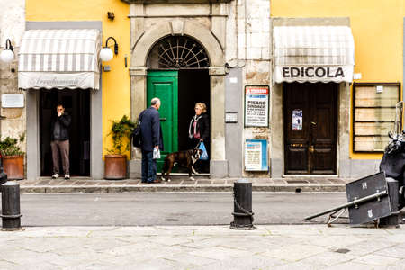 Pisa, Italy - March 17, 2012: Neighbors talking near the house on the street in the city of Pisa.のeditorial素材