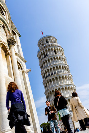 Pisa, Italy - March 17, 2012: People walking near the Tower of Pisa. Tower of Pisa (Torre di Pisa) is a freestanding bell tower of the cathedral in the Italian city of Pisa.のeditorial素材