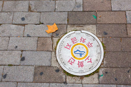 Seoul, South Korea - June 26, 2017: Round white sewer hatch on the street in Seoul downtownのeditorial素材