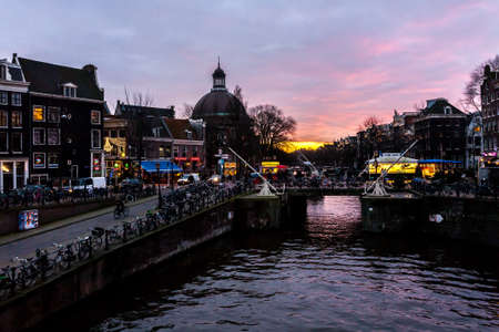 Amsterdam, The Netherlands - December 11, 2009: Bicycles on the street near water canal at nightのeditorial素材