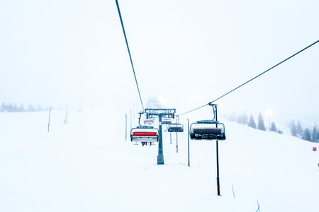Ruka, Finland - November 24, 2012: Skiers sitting on the chair ski lift at Ruka ski resort in freezing day.のeditorial素材