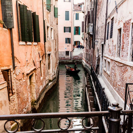 Venice, Italy - March 11, 2012: Typical Gondola with gondolier rowing along a narrow canal in Veniceのeditorial素材