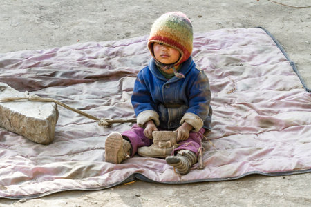Jhong, Nepal - November 17, 2015: Little Nepali child playing on the ground.のeditorial素材