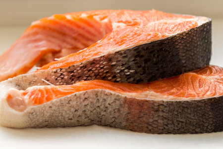 Two raw trout fillet on white background, side view, healthy food concept