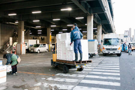 Tokyo, Japan - January 15, 2010: Early morning at the Fish Market. Loaders take boxes of seafood to the Tsukiji Fish Market.のeditorial素材