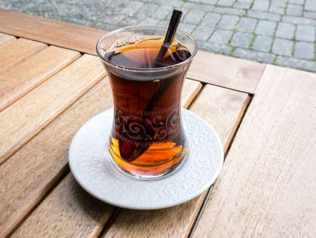 Hot Turkish tea in traditional glass with spoon on the wooden table on the street. Relaxation conceptの写真素材