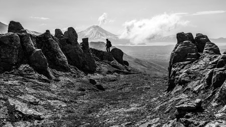 Black and white silhouette of the tourist on the peak of the mountain.の写真素材