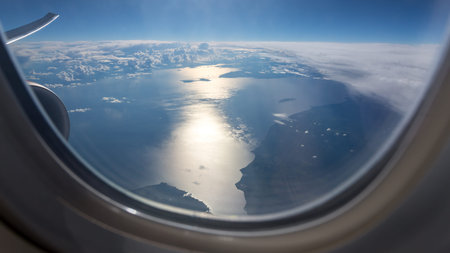 Sunset sea view from the airplane porthole. Traveling concept.の写真素材