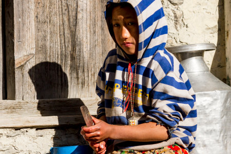 Jhong, Nepal - November 8, 2015: Nepali boy cutting potatoes near his house.のeditorial素材