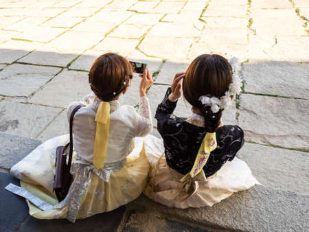 Seoul, South Korea - June 3, 2017: Gyeongbokgung Palace, Young women in colorful traditional wear - hanbok are taking a selfie by mobile phone.のeditorial素材