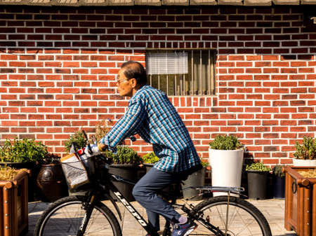 Seoul, South Korea - June 14, 2017: Elderly man riding a bike on the street of Seoul.のeditorial素材