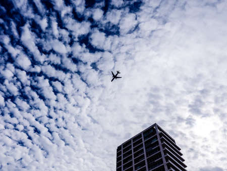 Airplane flying in the sky above the skyscraper. Tel-Aviv, Israelの写真素材