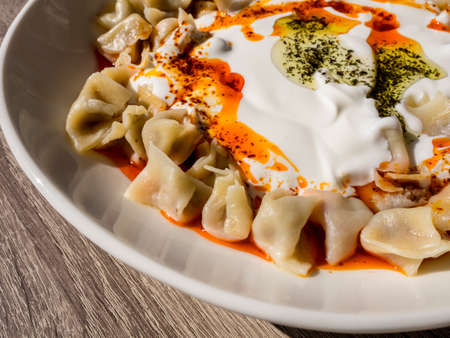 Turkish Manti with red pepper, tomato sauce, yogurt and mint. Plate of traditional Turkish food. top viewの写真素材