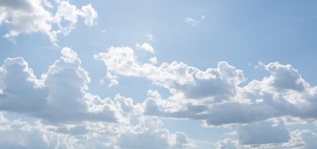 Blue sky on a sunny day. Soft texture of fluffy clouds. Concept for airy light dreams and travel.