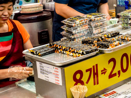 Seoul, South Korea - June 21, 2017: Woman vendor selling kimbap at Gwangjang Market in Seoul.