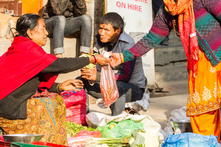 Kathmandu, Nepal - November 17, 2018: Elderly woman sells fruits and vegetables at the street market in Kathmanduのeditorial素材
