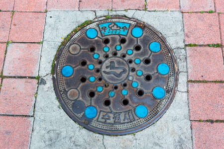 Round blue sewer hatch on the street in Seoul downtownの写真素材