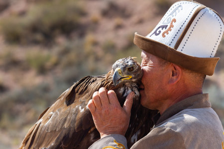 Tosor, Kyrgyzstan - October 1, 2022: Kyrgyz hunter or Berkutchi hugging a golden eagle, Kyrgyzstan.のeditorial素材