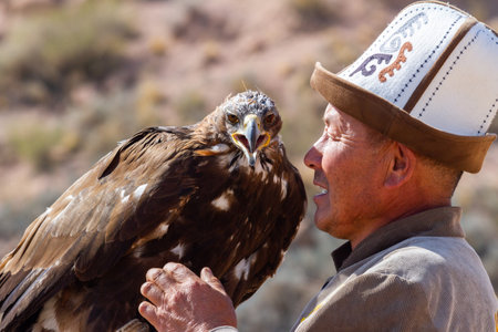 Tosor, Kyrgyzstan - October 1, 2022: Kyrgyz hunter or Berkutchi hugging a golden eagle, Kyrgyzstan.のeditorial素材