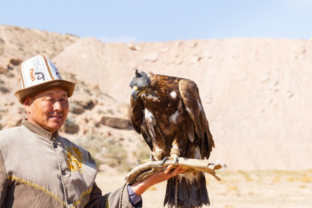 Tosor, Kyrgyzstan - October 1, 2022: Kyrgyz hunter or Berkutchi holding a golden eagle on his hand, Kyrgyzstan.のeditorial素材