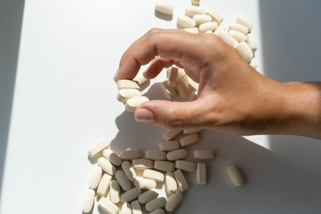 Hand takes medicine vitamin capsules or pills. Health care or medical concept.の写真素材
