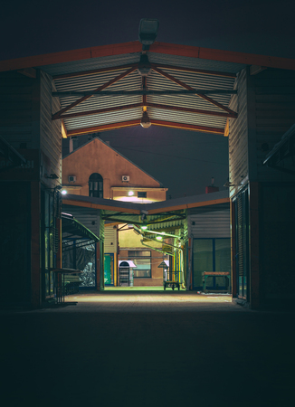 Central marketplace at night time. Isolated territory filled with trading stands and lighten by city lights. Spooky and abandoned atmosphere in urban market territory.のeditorial素材