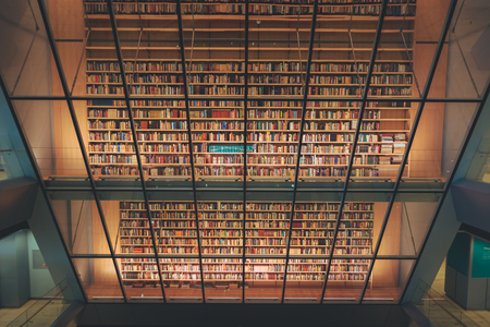 Huge bookshelf with tons of colorful books behind a glass wall. Collection of books in National library of Latvia. Modern architectural masterpiece.のeditorial素材