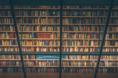 Huge bookshelf with tons of colorful books behind a glass wall. Collection of books in National library of Latvia. Modern architectural masterpiece.のeditorial素材