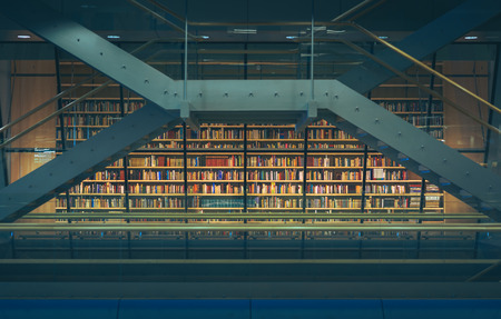 Huge bookshelf with tons of colorful books behind a glass wall. Collection of books in National library of Latvia. Modern architectural masterpiece.のeditorial素材