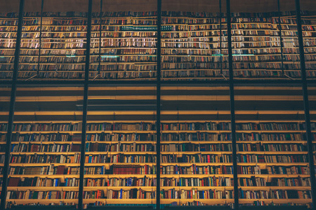 Huge bookshelf with tons of colorful books behind a glass wall. Collection of books in National library of Latvia. Modern architectural masterpiece.のeditorial素材