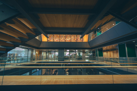 National library of Latvia. Modern architectural masterpiece. Multilevel floors with staircases and bookshelves in background.のeditorial素材