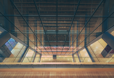 Huge bookshelf with tons of colorful books behind a glass wall. Collection of books in National library of Latvia. Modern architectural masterpiece.のeditorial素材
