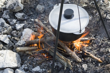Pot over the fire in the forest. Cooking on a fire. Spring camping concept. Opening of the new tourist season. Vertical.の写真素材
