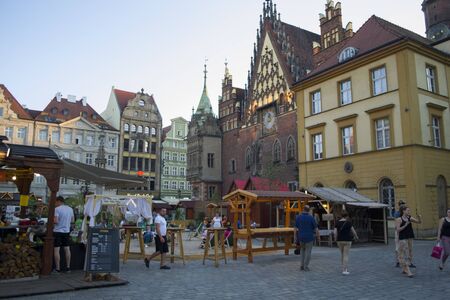 Wroclaw, Poland - June 3th, 2019: Market square in the Wroclaw old city center. Tourists enjoy a pleasant evening at the city hall.のeditorial素材